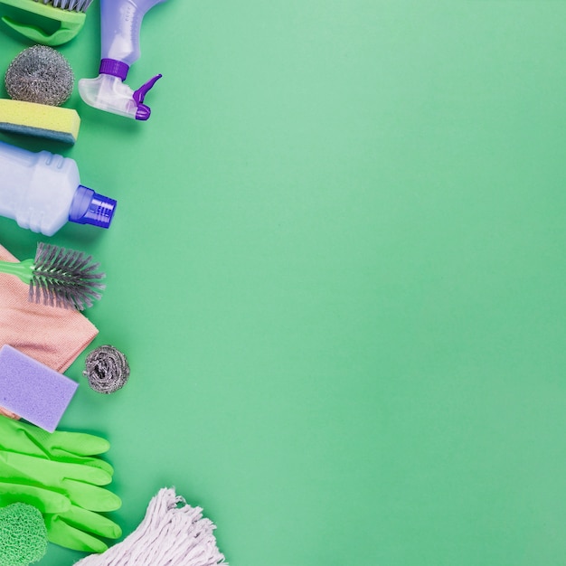 Elevated view of cleaning products on green background