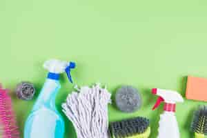 Free photo elevated view of cleaning supplies on green backdrop