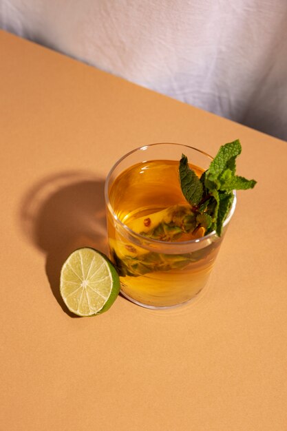 Повышенный вид коктейль с половиной лимона на коричневый стол