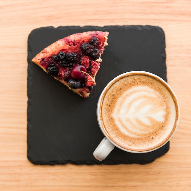 Elevated view of coffee and berry pastry on wooden table
