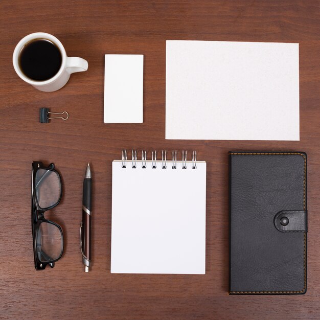 Elevated view of coffee cup and office stationery on wooden desk