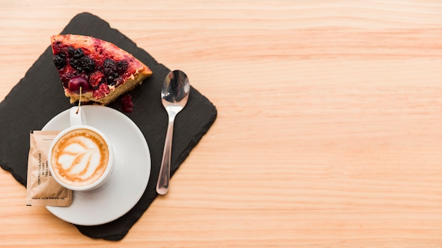 Elevated view of coffee latte and pastry on wooden table