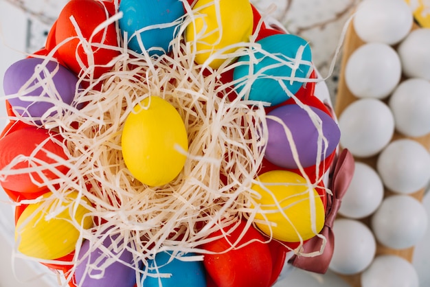 An elevated view of colorful easter eggs on shredded paper