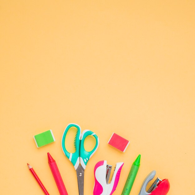 Elevated view of craft accessories over plain colored backdrop