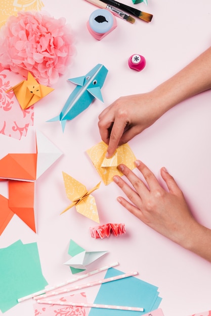 Elevated view of craftswoman making craft with origami paper