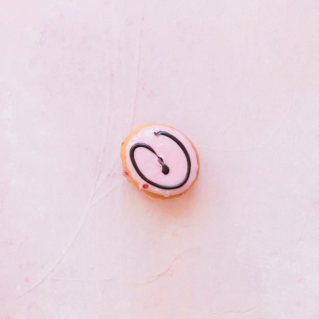 Elevated view of decorative donut on pink background