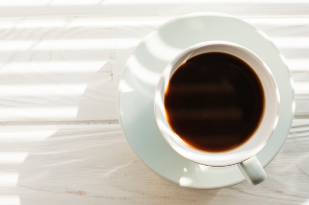 Elevated view of delicious coffee cup over white wooden table