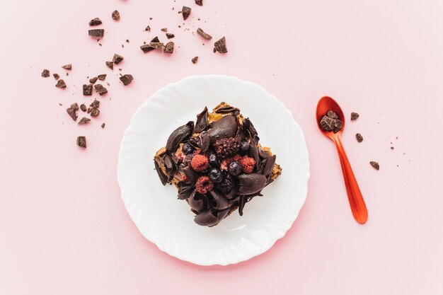 Elevated view of delicious pastry on plate over pink background