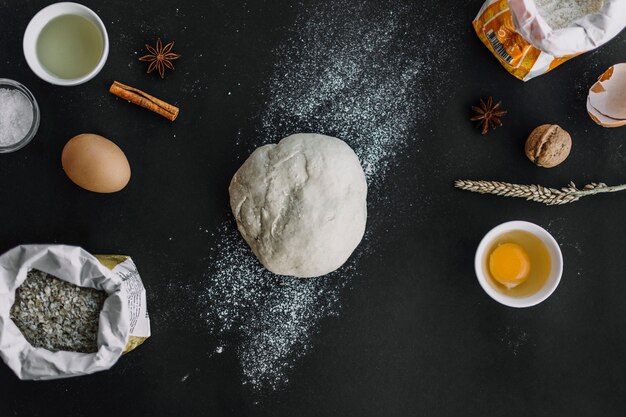 Elevated view of dough and baking ingredients on black background