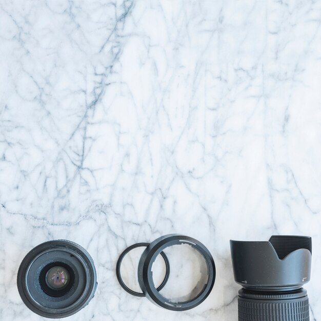 Повышенный вид камеры DSLR с объективом и удлинительные кольца на фоне мрамора