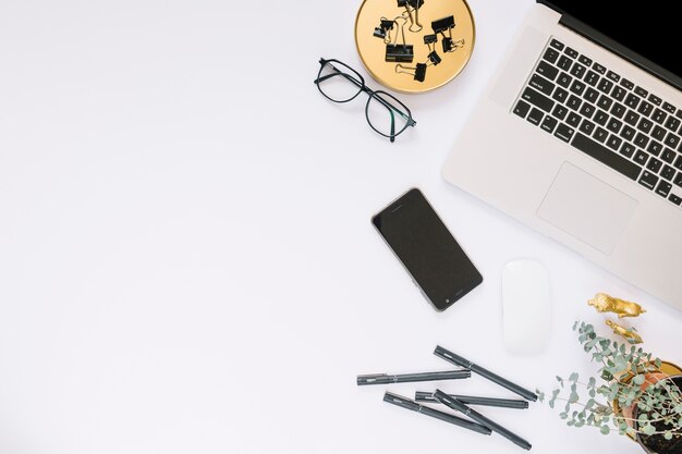 Elevated view of electronic devices and stationeries on white backdrop