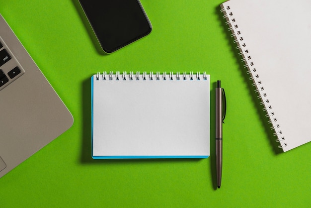 Elevated view of electronic gadget with notebook and pen