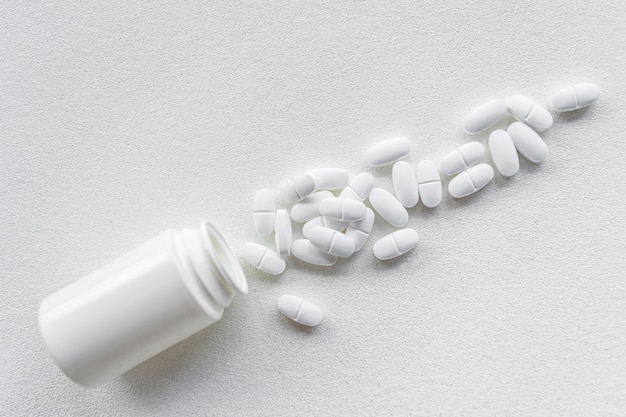 Elevated view of a fallen white pills bottle