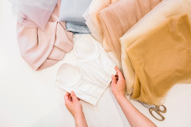 Elevated view of fashion designer's hand working on fabrics in studio