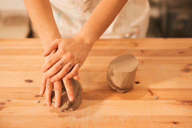 木製のテーブルに粘土を混練する女性の高角度のビュー