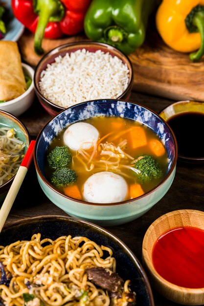 An elevated view of fish ball soup with rice; sauces and noodles