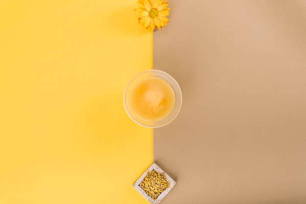 Elevated view of flowers; lemon curd and bee pollen on dual colored background