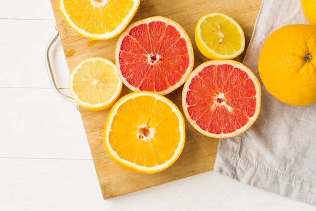 Elevated view of fresh citrus fruits on chopping board