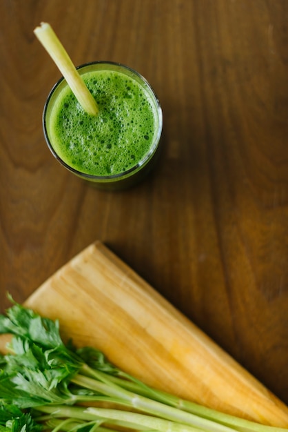 Elevated view of fresh green smoothie on wooden desk