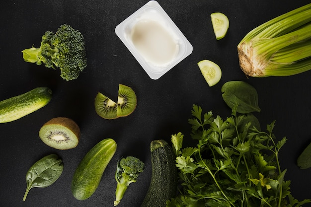 Elevated view of fresh green vegetables on green backdrop