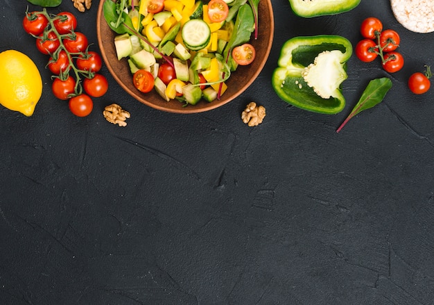 An elevated view of fresh healthy vegetable salad on black kitchen counter