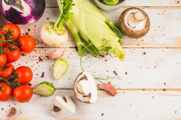 Elevated view of fresh vegetables and chili flakes on wooden background