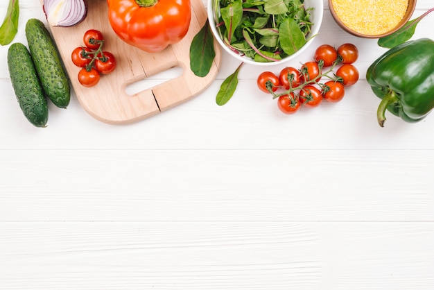 An elevated view of fresh vegetables on white wooden desk