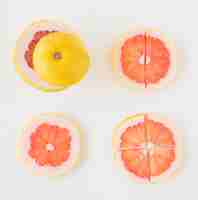 Free photo an elevated view of grapefruit cut in different slices on white backdrop