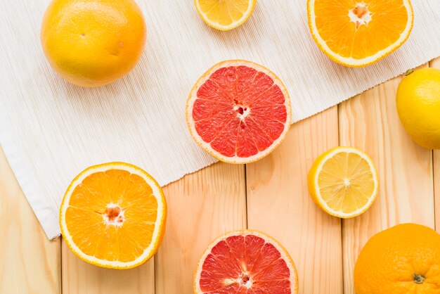 Elevated view of halved citrus fruits on wooden background