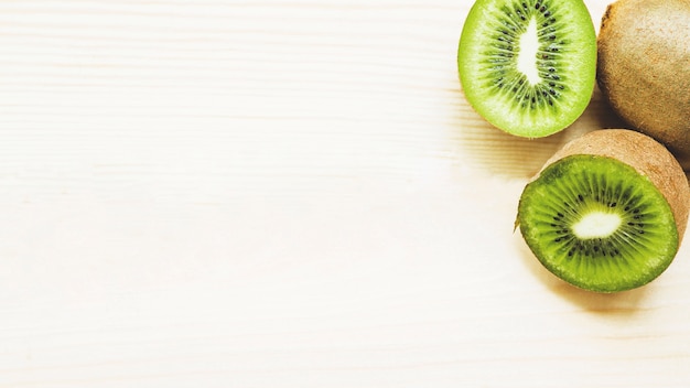 Elevated view of halved kiwi fruits on wooden background