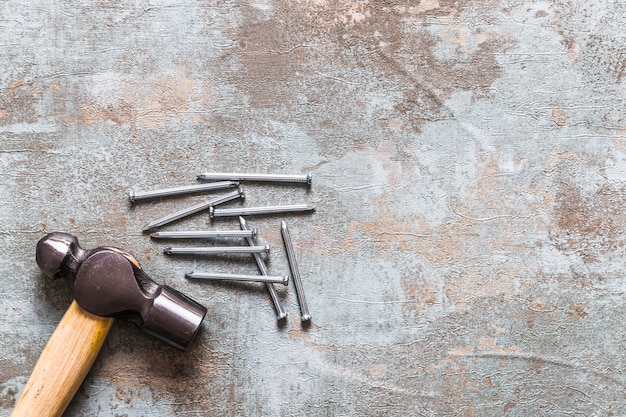 Elevated view of hammer and nails on old wooden desk