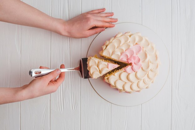 Elevated view of a hand holding spatula with cake slice