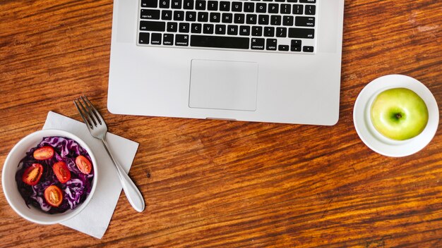 Elevated view of healthy food and laptop on wooden desk