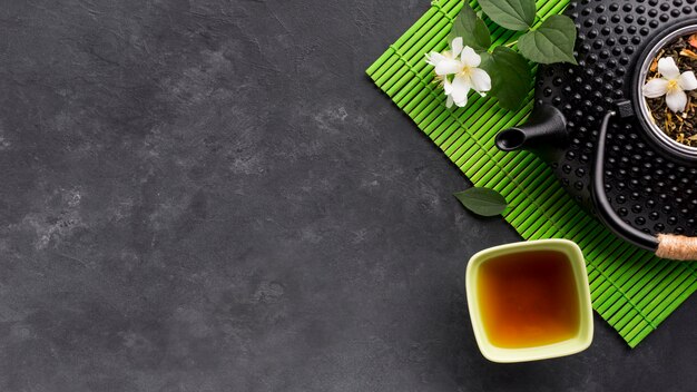 Elevated view of herbal tea and it's ingredient on black textured surface