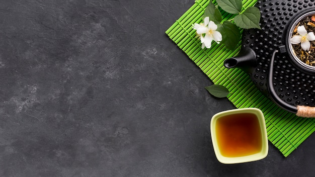 Elevated view of herbal tea and it's ingredient on black textured surface