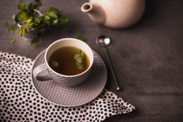 Elevated view of herbal tea and polka dotted textile on table