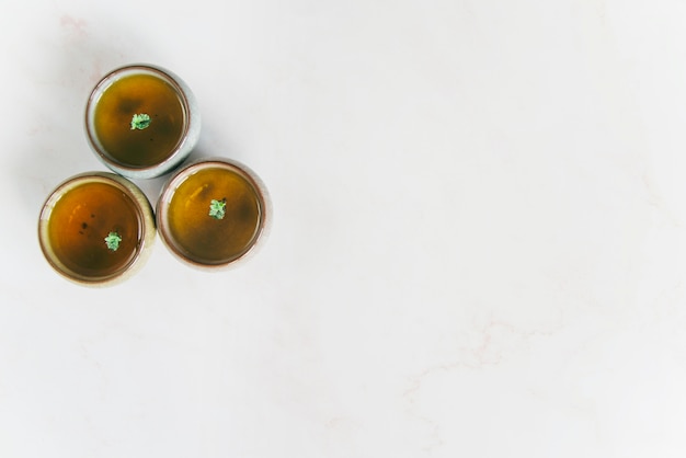 An elevated view of herbal teacups on white background