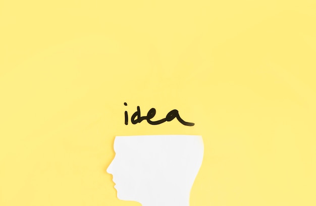 Elevated view of human head with idea word on yellow background