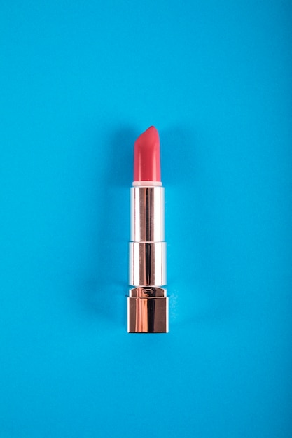 Elevated view of lipstick on blue background