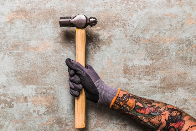 Elevated view of a man holding hammer on wooden desk