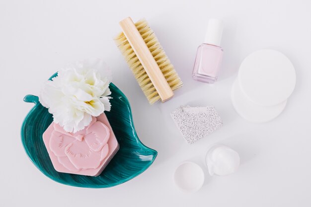 Elevated view of manicure products with pink soap bar on white surface