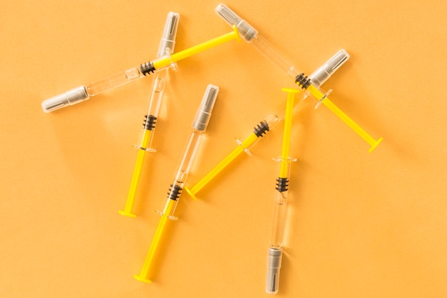 Free photo elevated view of medical syringes on yellow background