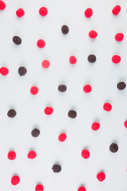 컬러 배경에 빨간색과 검은 색 크랜베리 사탕의 높은보기