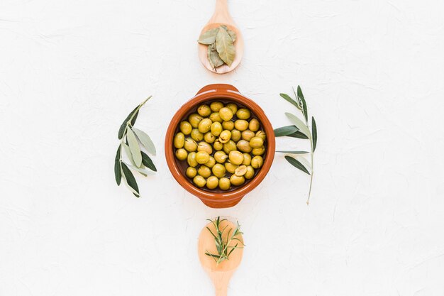 Elevated view of olive oil with rosemary on white background