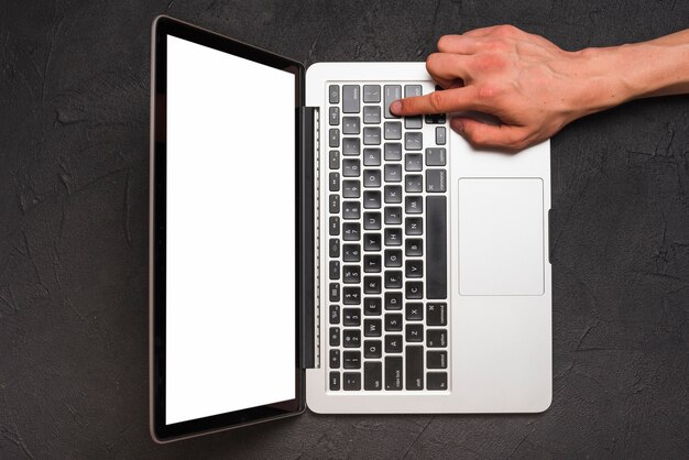 Elevated view of a person's hand using laptop on black background