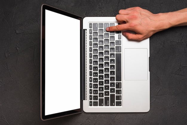 Elevated view of a person's hand using laptop on black background