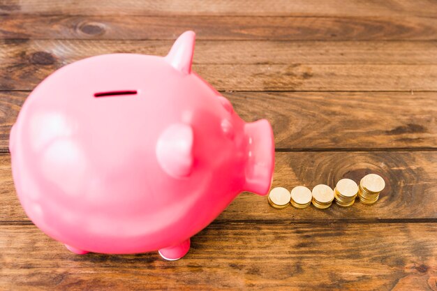 Free photo elevated view of pink piggybank near increasing stacked coins