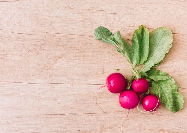 An elevated view of pink turnip on wooden textured