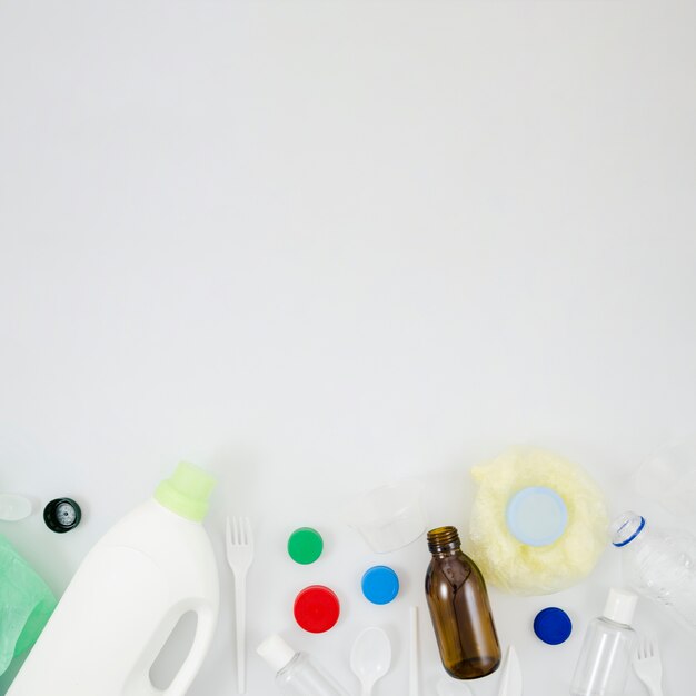 Elevated view of plastic waste garbage at bottom of white background