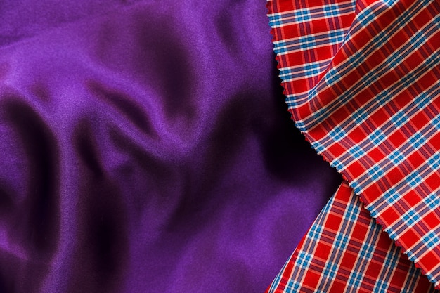 Elevated view of red chequered pattern and plain purple textile